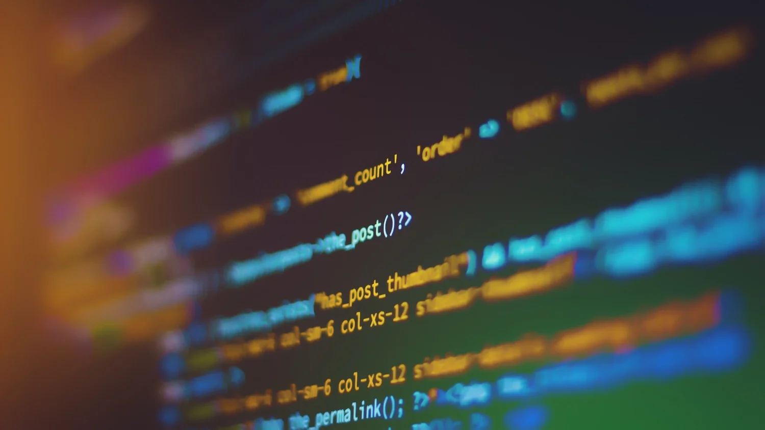 Close-up of colourful source code on a dark screen