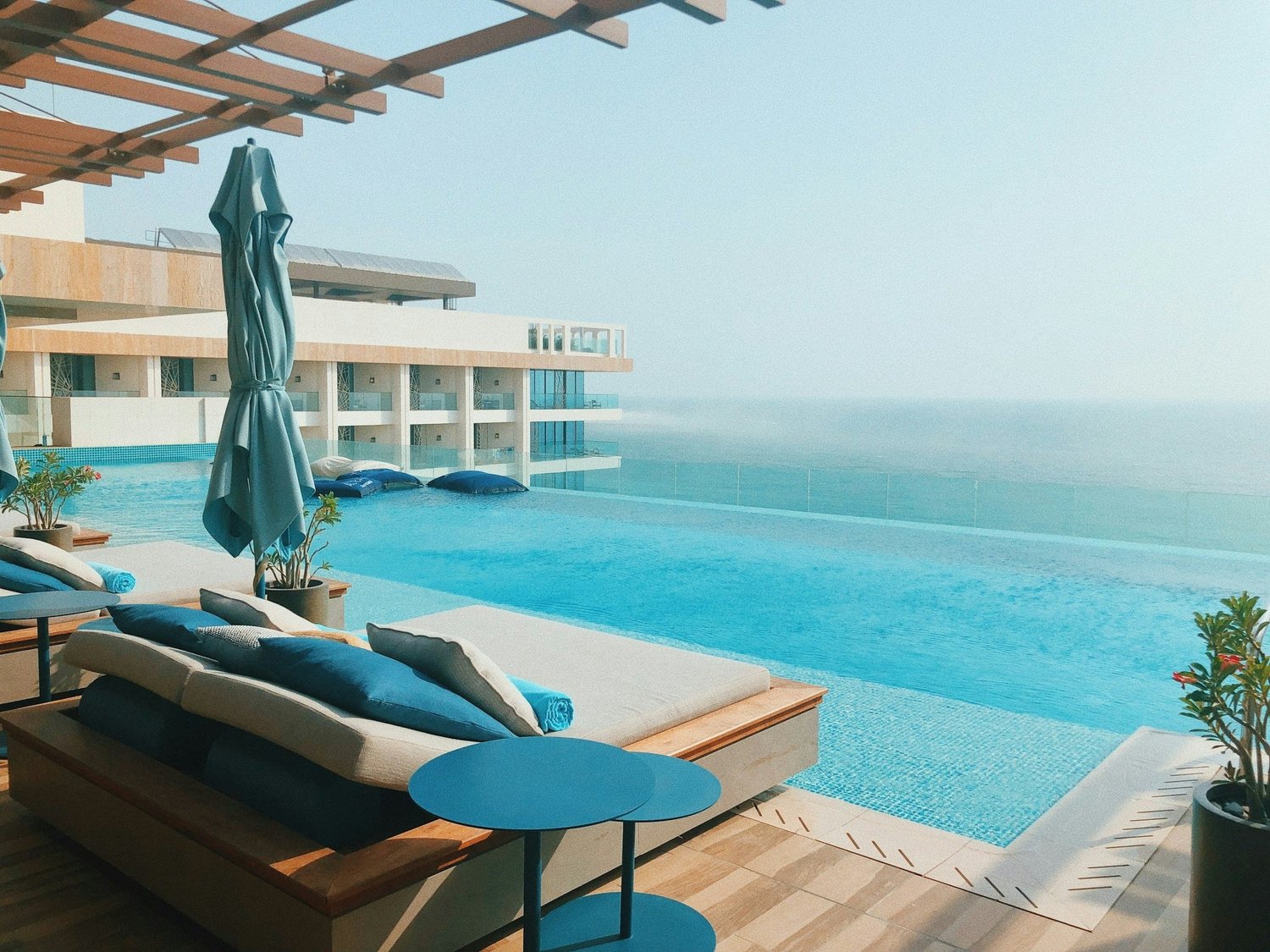Infinity pool and shaded daybeds at a seaside resort